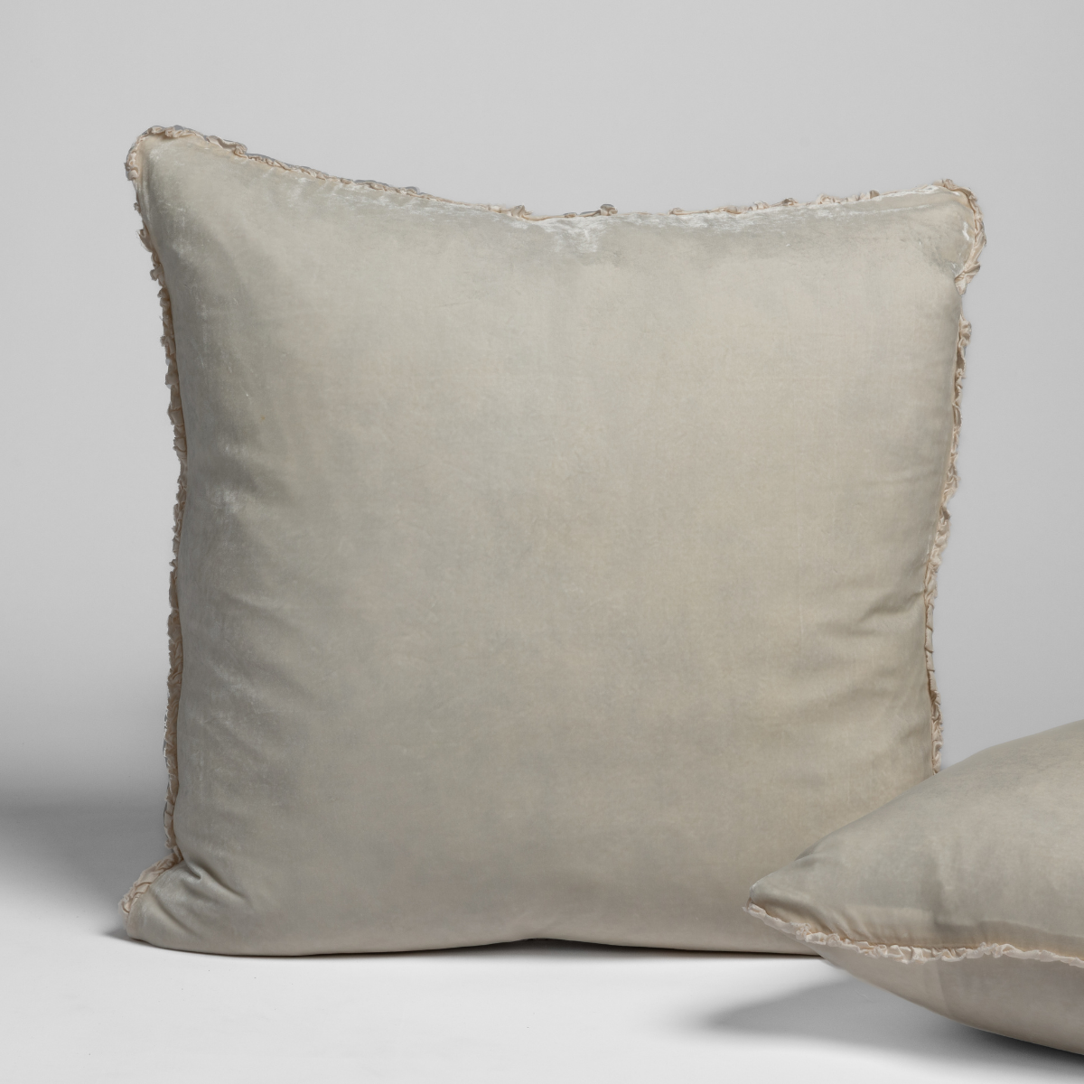 Bella Notte Carmen sham in Crema, showing fringe trim detail with a second sham partially visible.