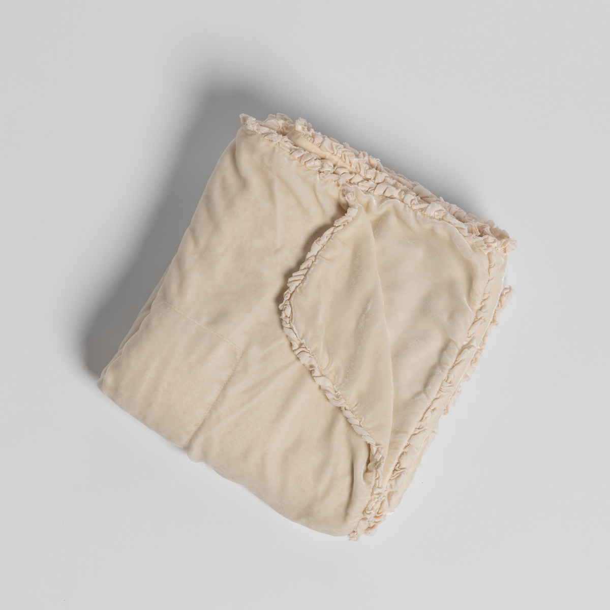 Bella Notte Carmen blanket in Crema, folded to show fringe trim detail.