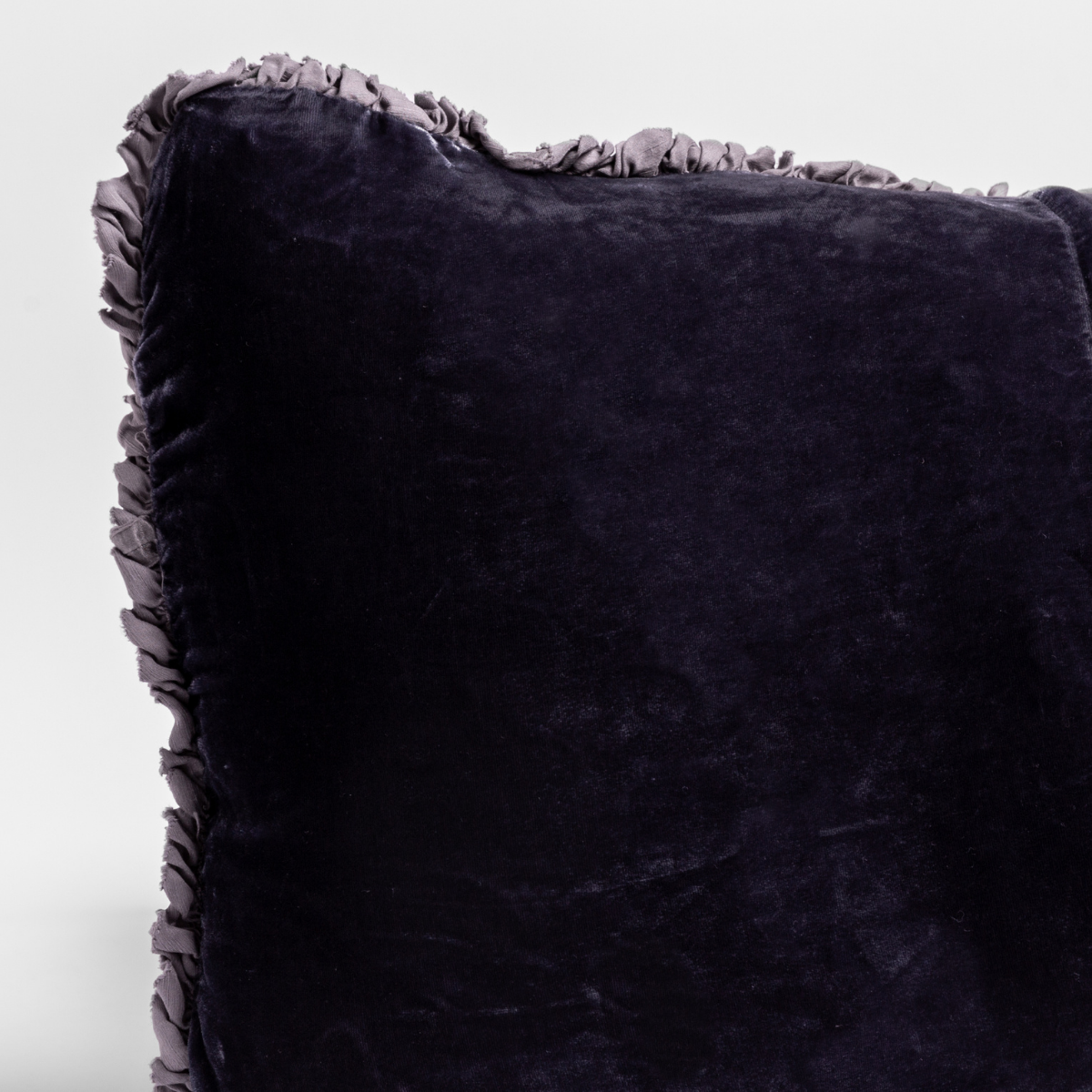 Close-up of French Lavender velvet pillow corner with ruffled trim detail.