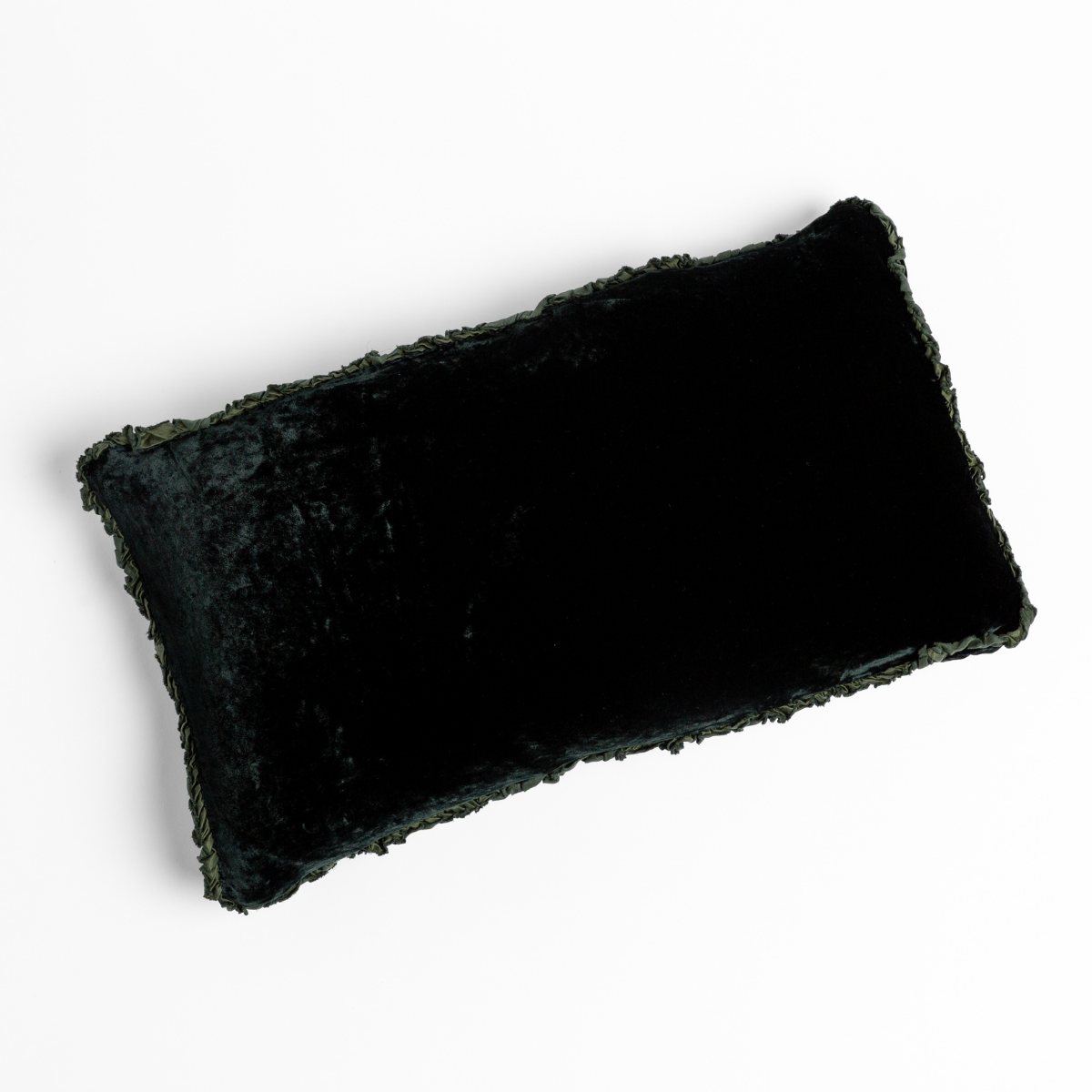 Juniper crushed velvet lumbar pillow with textured fringe trim, angled flat-lay view.