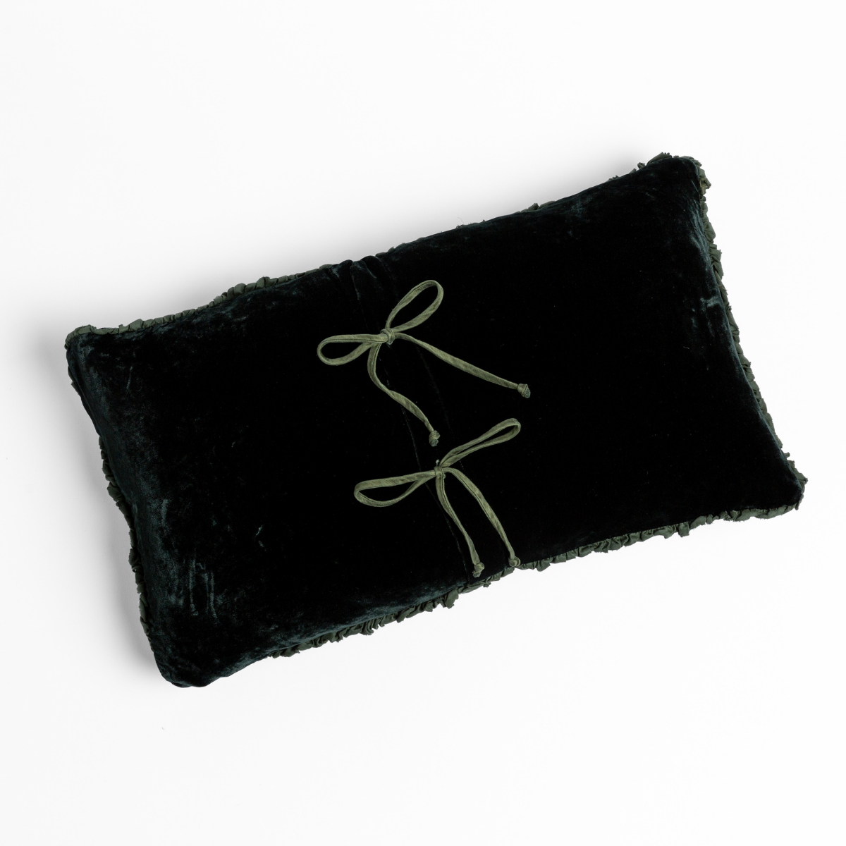 Dark Juniper velvet lumbar pillow with two olive bow embroideries and shaggy fringe trim.