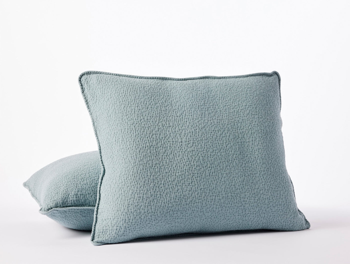Pair of Coyuchi Cascade Matelassé shams in dusty blue with textured boucle surface.