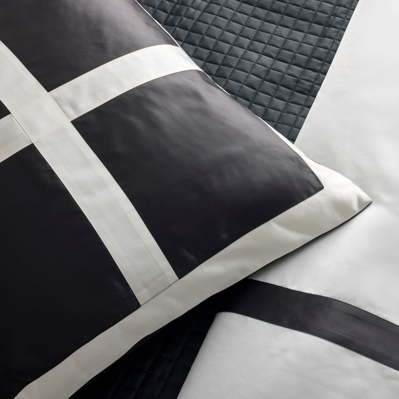 Close-up of Ann Gish Cavendish pillow with bold black and white grid border detail.