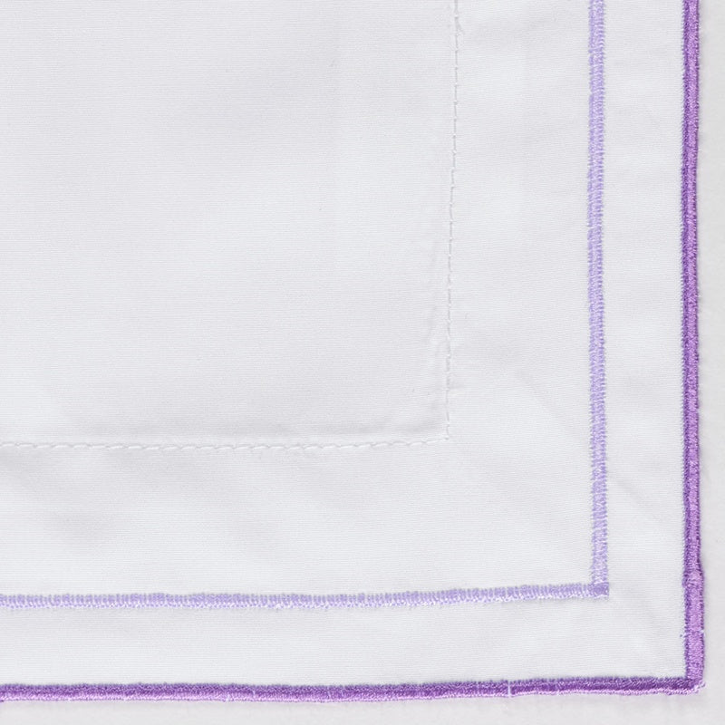 Close-up of white fabric with a subtle stripe and purple embroidered border, featuring Areo Pillowcase by Celso de Lemos available at Linen Society.