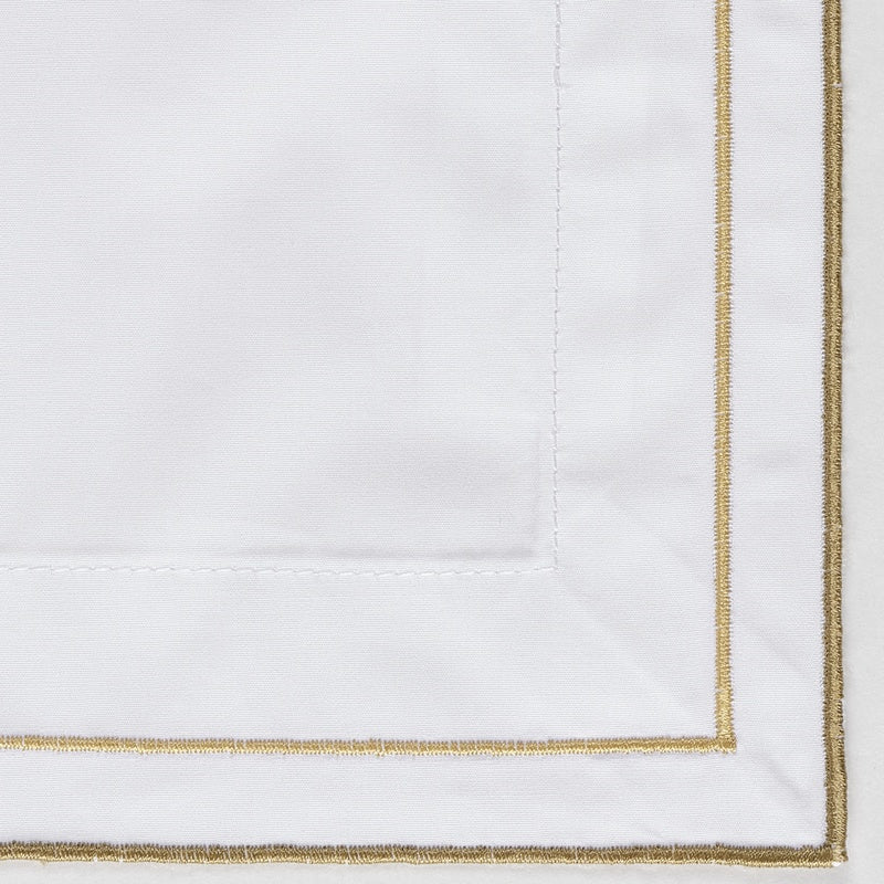 Close-up of white textile with gold piping and stitching, featuring Areo Pillowcase by Celso de Lemos available at Linen Society.