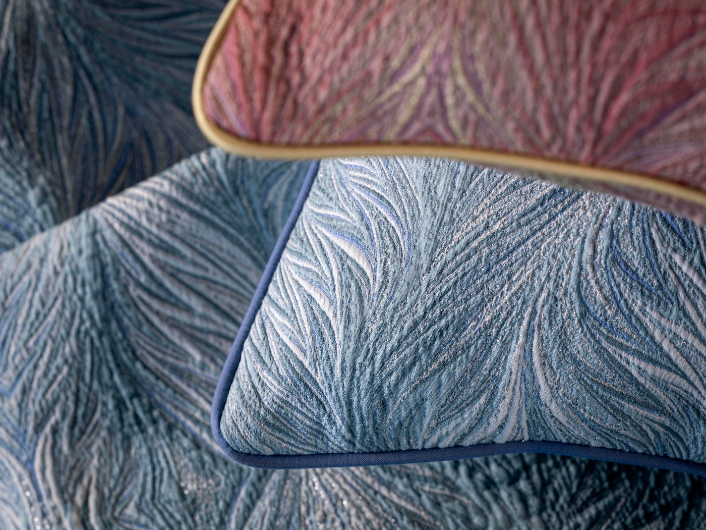 Close-up of textured blue and pink pillow covers with metallic threads, featuring Boheme Pillow Cover by Celso de Lemos available at Linen Society.