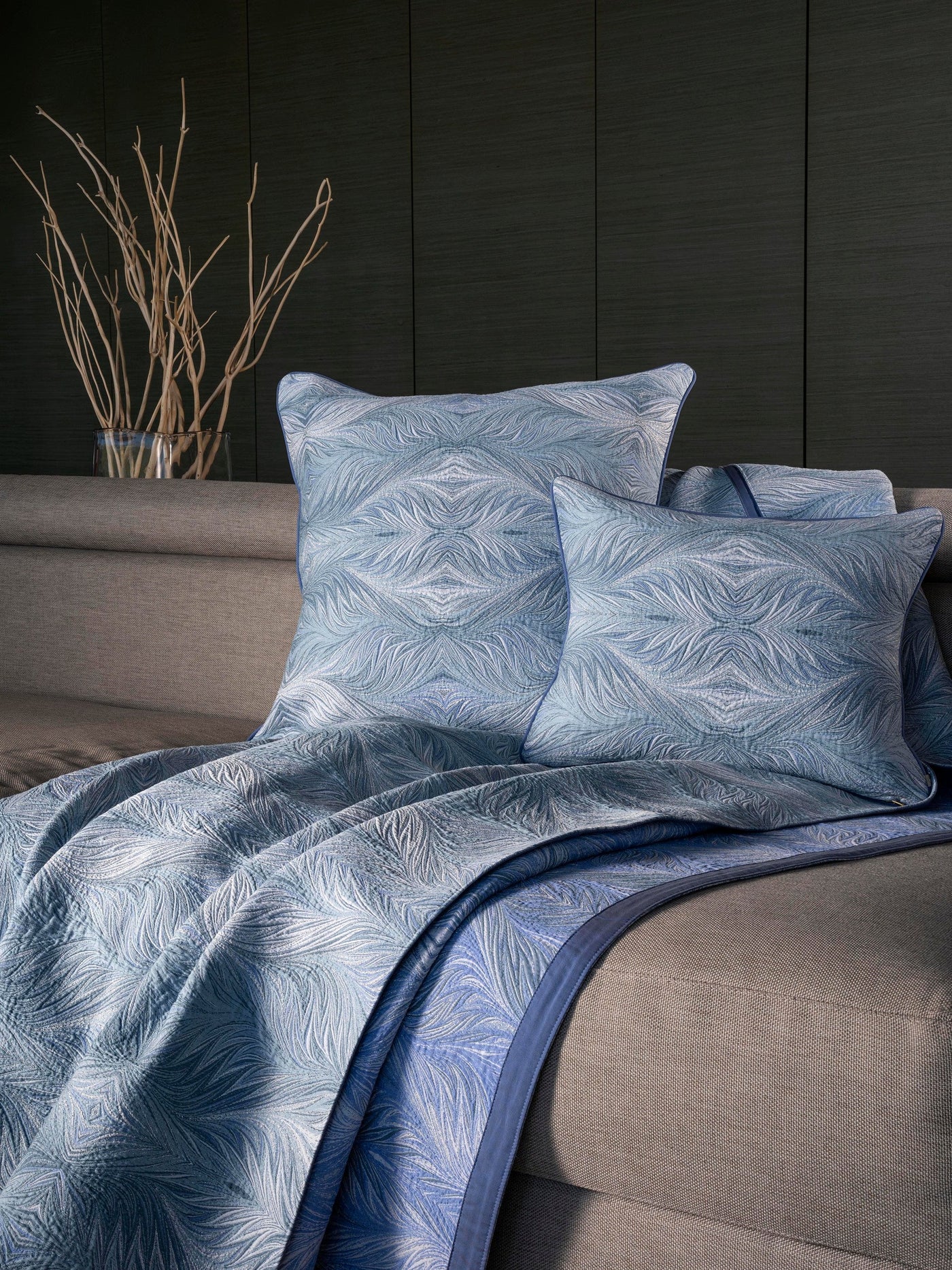 Blue patterned pillows and throw blanket layered on a sofa featuring Boheme Pillow Cover by Celso de Lemos available at Linen Society.