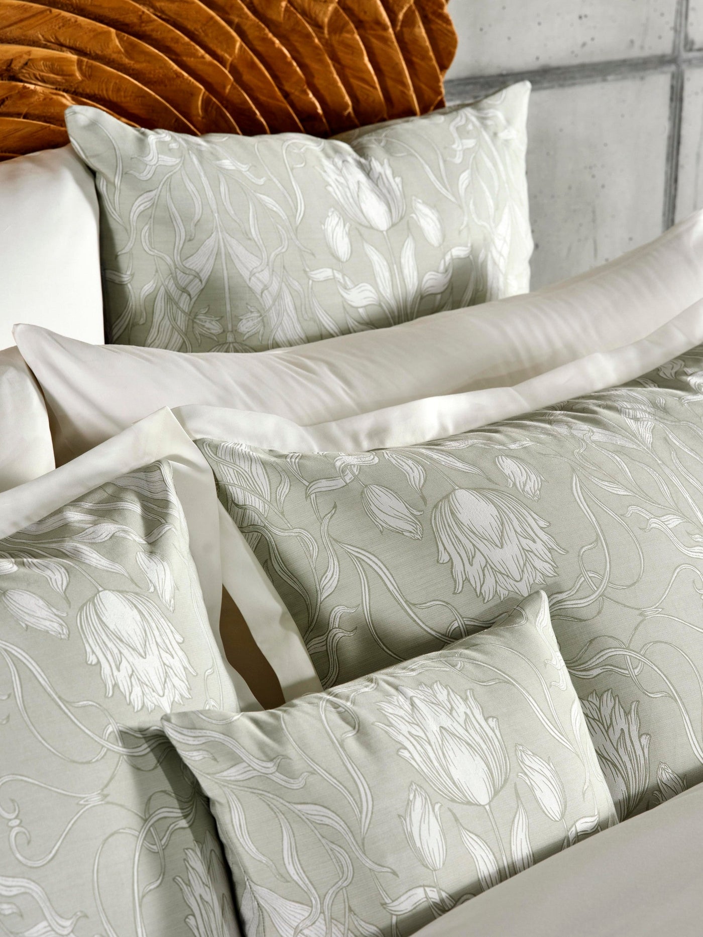 Soft sage green pillowcases with a white botanical floral pattern arranged on a bed featuring Celso de Lemos Botanica Pillowcase by Celso de Lemos available at Linen Society.