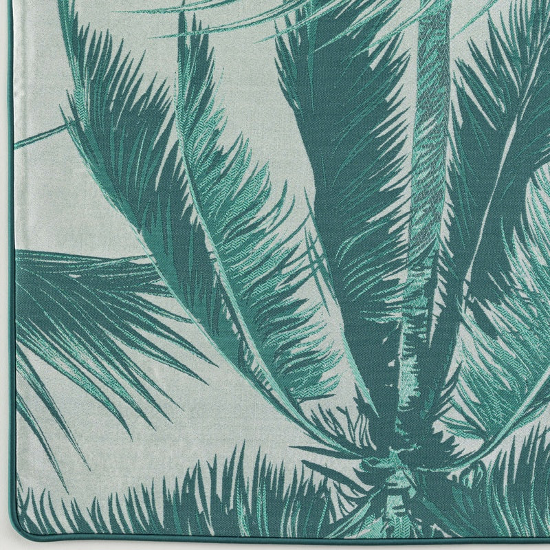 Close-up of a teal palm frond pattern on a light grey background, featuring Cabo Verde Pillow Cover by Celso de Lemos available at Linen Society.