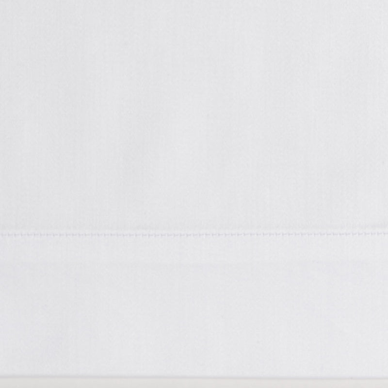 Close-up of white fabric with a subtle texture and stitched hem detail, featuring the Capela Pillowcase by Celso de Lemos available at Linen Society.