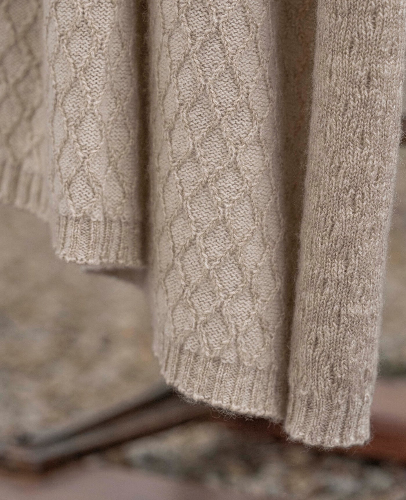 Close-up of Celso de Lemos Cécile throw showing oatmeal diamond cable-knit texture and ribbed hem.