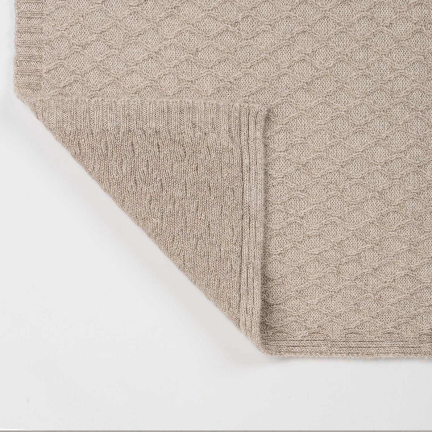 Corner detail of Celso de Lemos Cécile throw showing taupe honeycomb knit texture and folded edge.