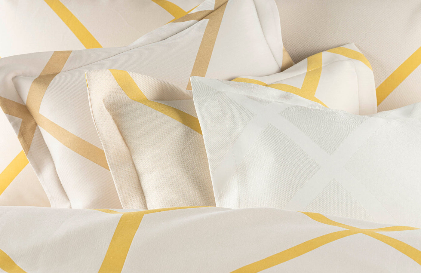 Close-up of white and gold geometric pattern pillowcases, featuring Charleston Pillowcase by Celso de Lemos available at Linen Society.