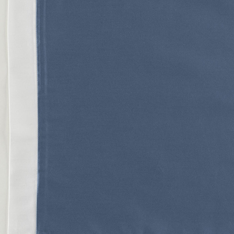 Close-up view of a blue fabric with a white border, featuring Emma Pillowcase by Celso de Lemos available at Linen Society.