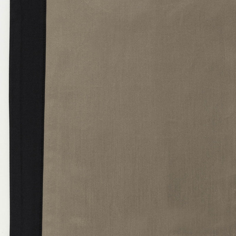 Close-up of taupe linen fabric with a black border edge detail.