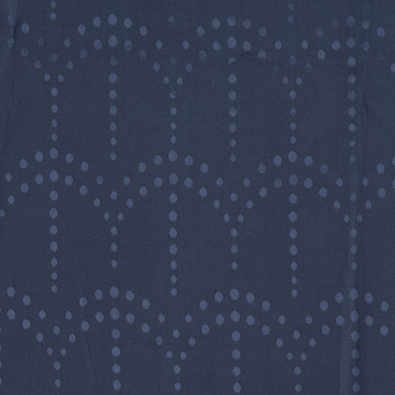 A close-up of dark blue fabric with a subtle diamond-shaped dot pattern, featuring Evora Pillowcase by Celso de Lemos available at Linen Society.