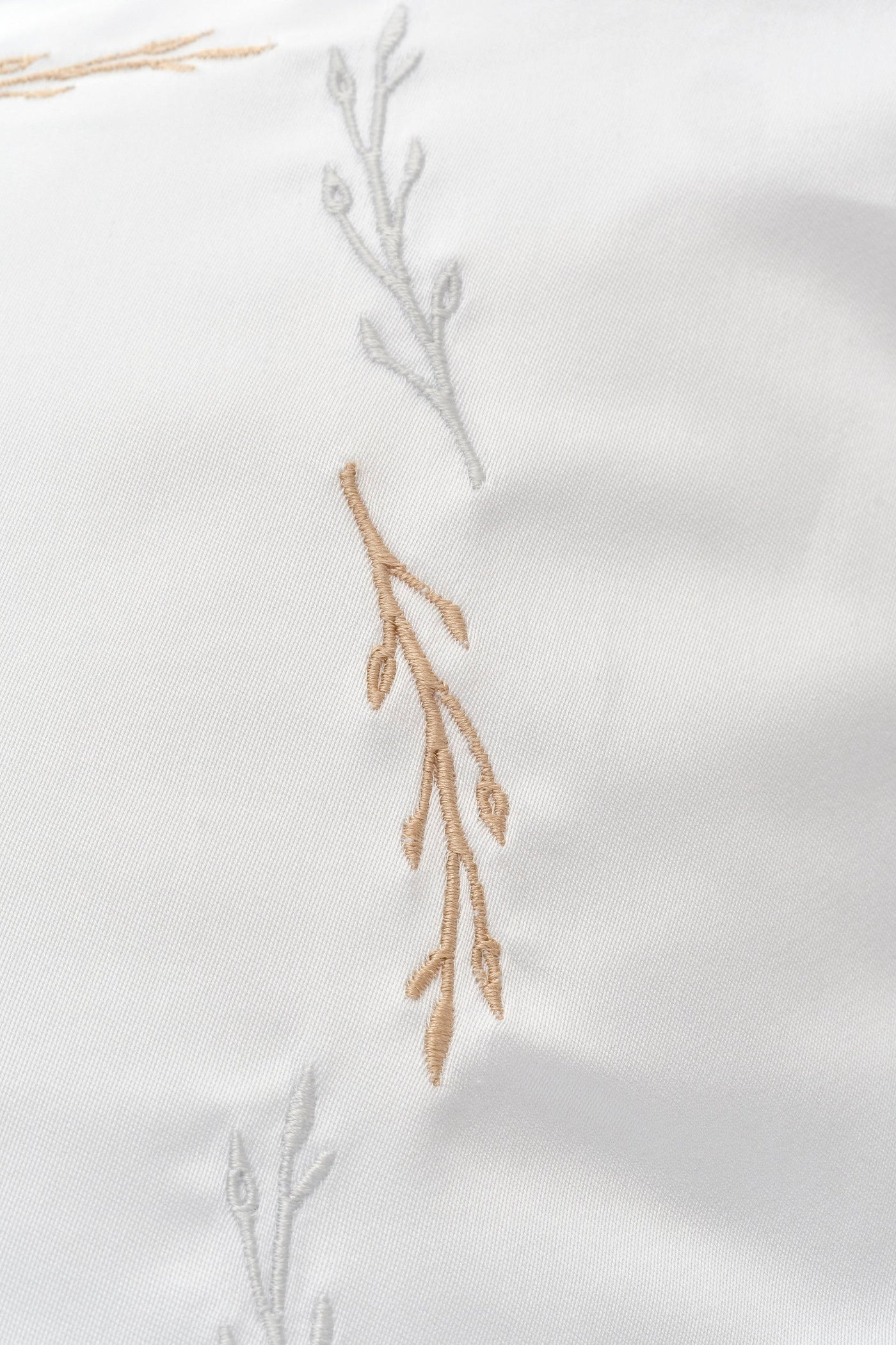 White Pillowcase with delicate tan and silver embroidered branch details, featuring Fern Pillowcase by Celso de Lemos available at Linen Society.