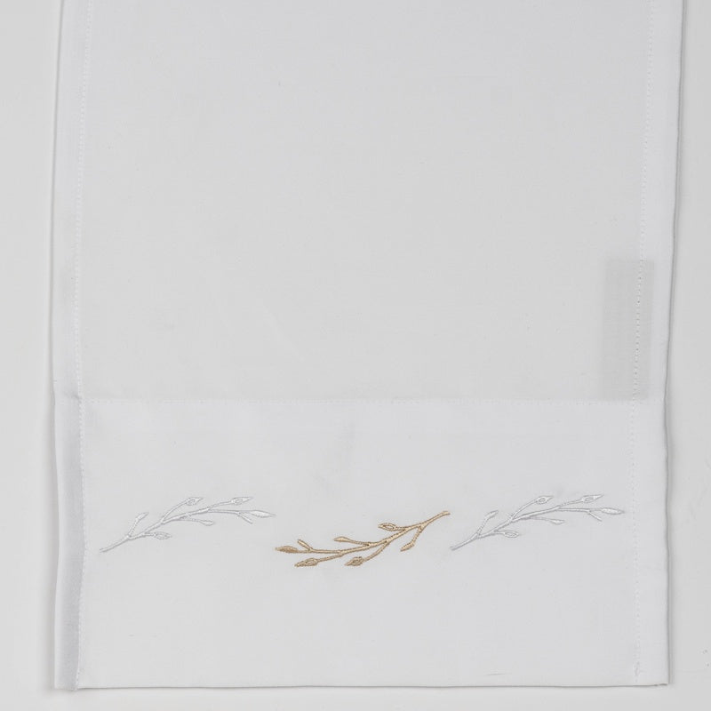 White textile with embroidered branches in gold and silver, featuring Fern Pillowcase by Celso de Lemos available at Linen Society.