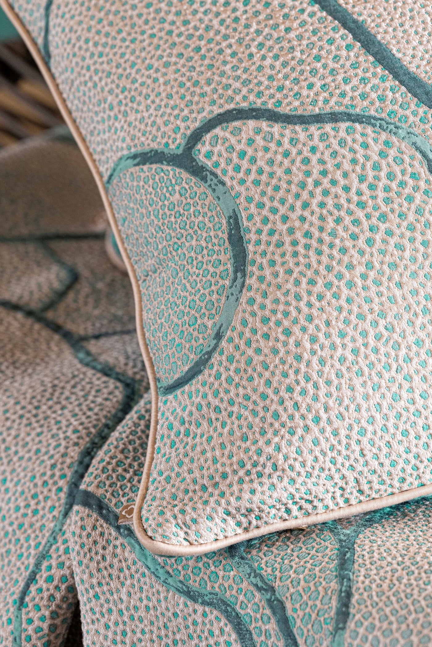 Close-up of a textured pillow with a beige and teal abstract pattern. featuring Funchal Pillow Cover by Celso de Lemos available at Linen Society.