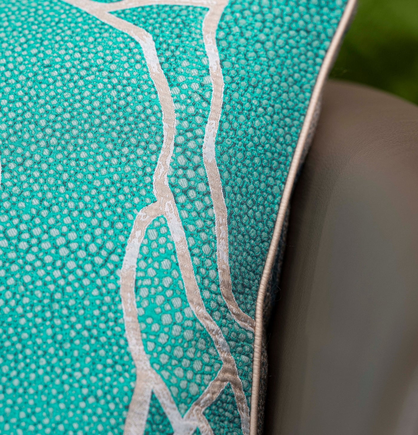 Close-up on a textured teal pillow cover with a raised beige pattern, featuring Funchal Pillow Cover by Celso de Lemos available at Linen Society.