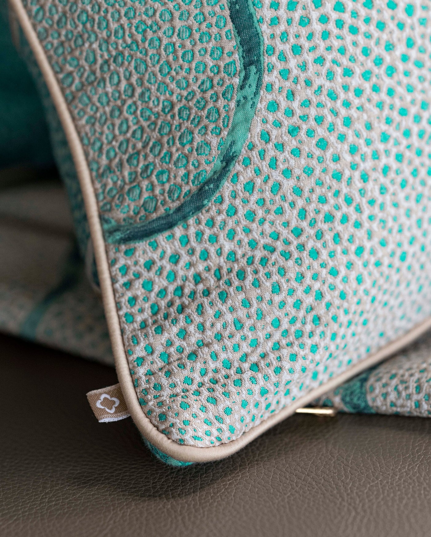 Close-up of a textured pillow with a light grey base and teal dot pattern, featuring the Funchal Pillow Cover by Celso de Lemos available at Linen Society.