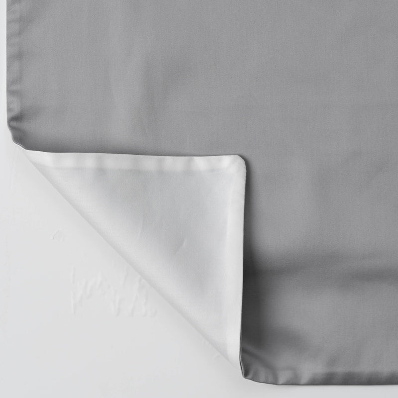 A gray pillowcase is shown unfolded with the white underside visible, featuring Gemini Pillowcase by Celso de Lemos available at Linen Society.