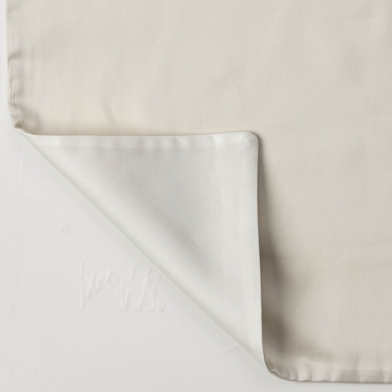 A light beige pillowcase is shown flat, with one corner folded back to reveal the smooth, white underside. featuring Gemini Pillowcase by Celso de Lemos available at Linen Society.