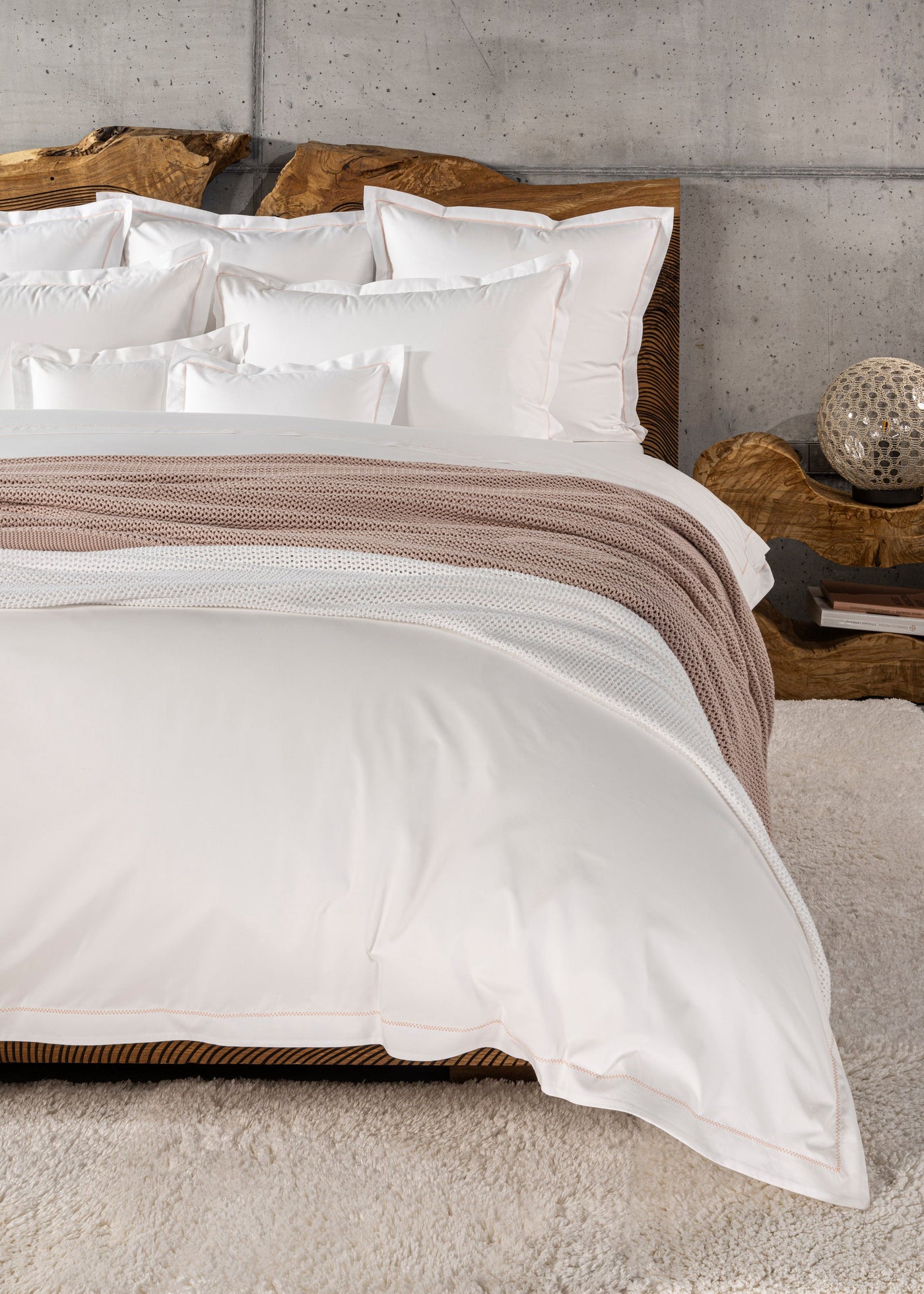 Crisp white pillowcases with subtle stitched detailing are neatly arranged on a bed. featuring Ivy Pillowcase by Celso de Lemos available at Linen Society.