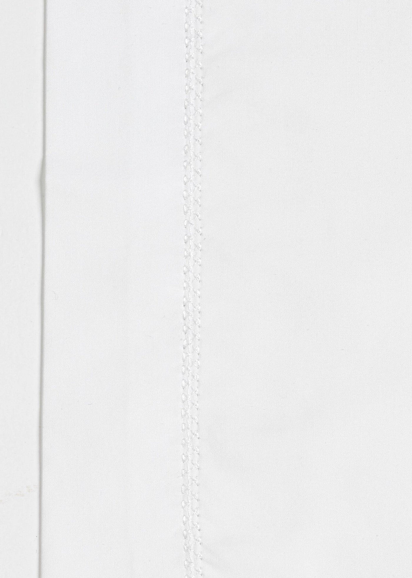 Close-up of white fabric with a decorative stitch detail, featuring Ivy Pillowcase by Celso de Lemos available at Linen Society.
