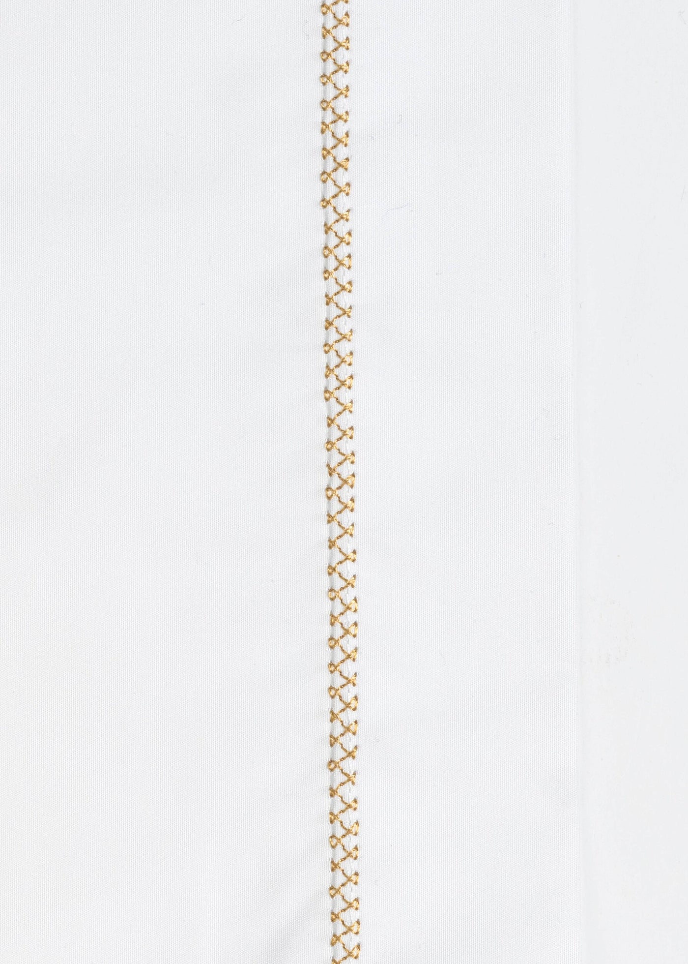 White fabric with a gold embroidered stitch detail down the center, featuring Ivy Pillowcase by Celso de Lemos available at Linen Society.