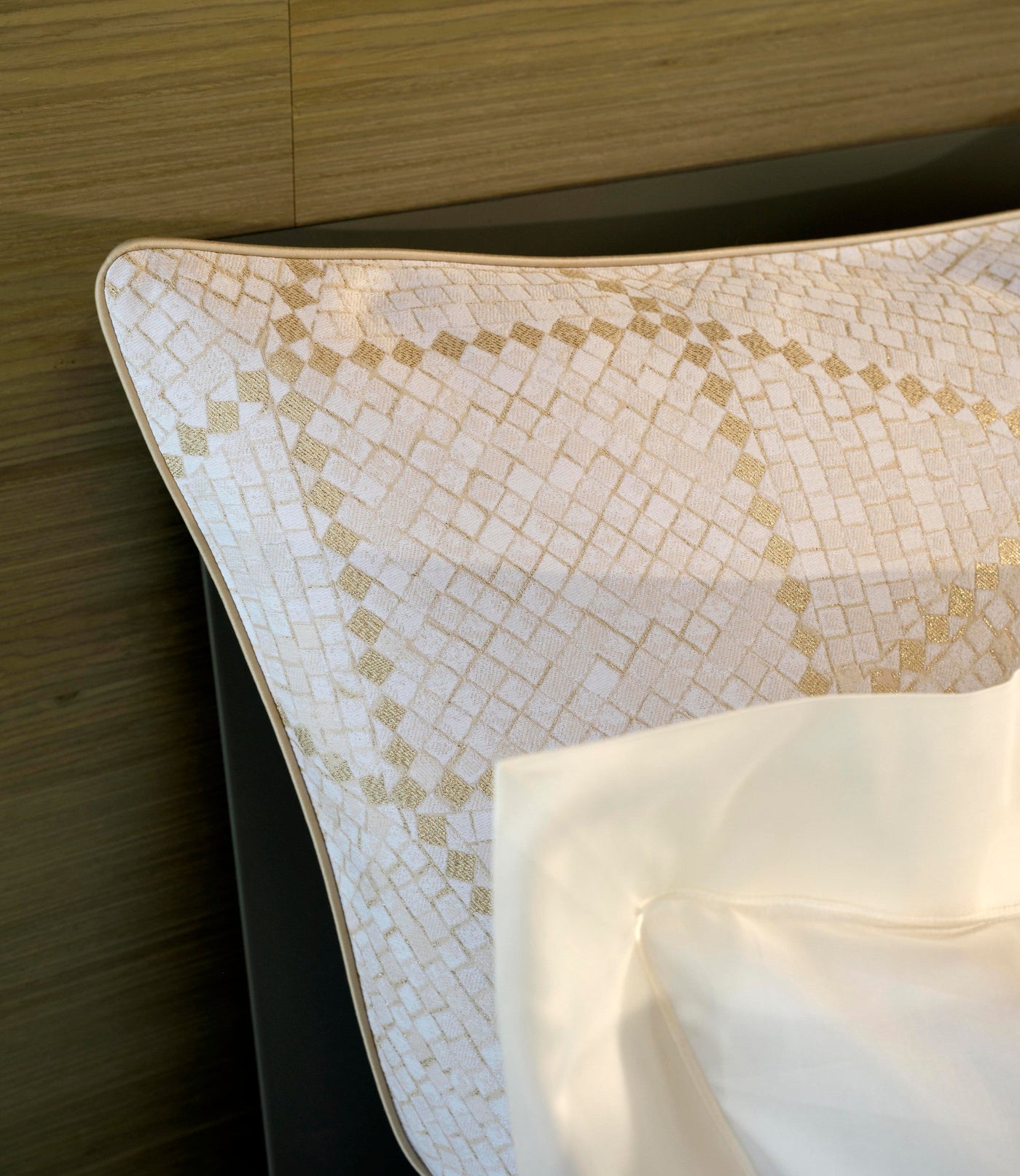 Close-up of a white pillowcase with a gold geometric pattern and a cream border, featuring Kerylos Pillowcase by Celso de Lemos available at Linen Society.