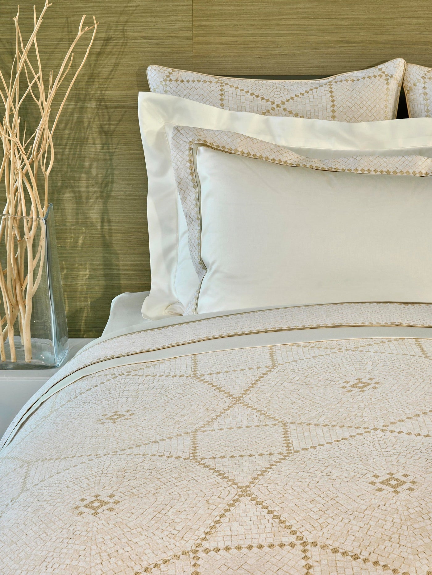A bed styled with plush pillows and a duvet featuring a geometric pattern in neutral tones, featuring Kerylos Pillowcase by Celso de Lemos available at Linen Society.