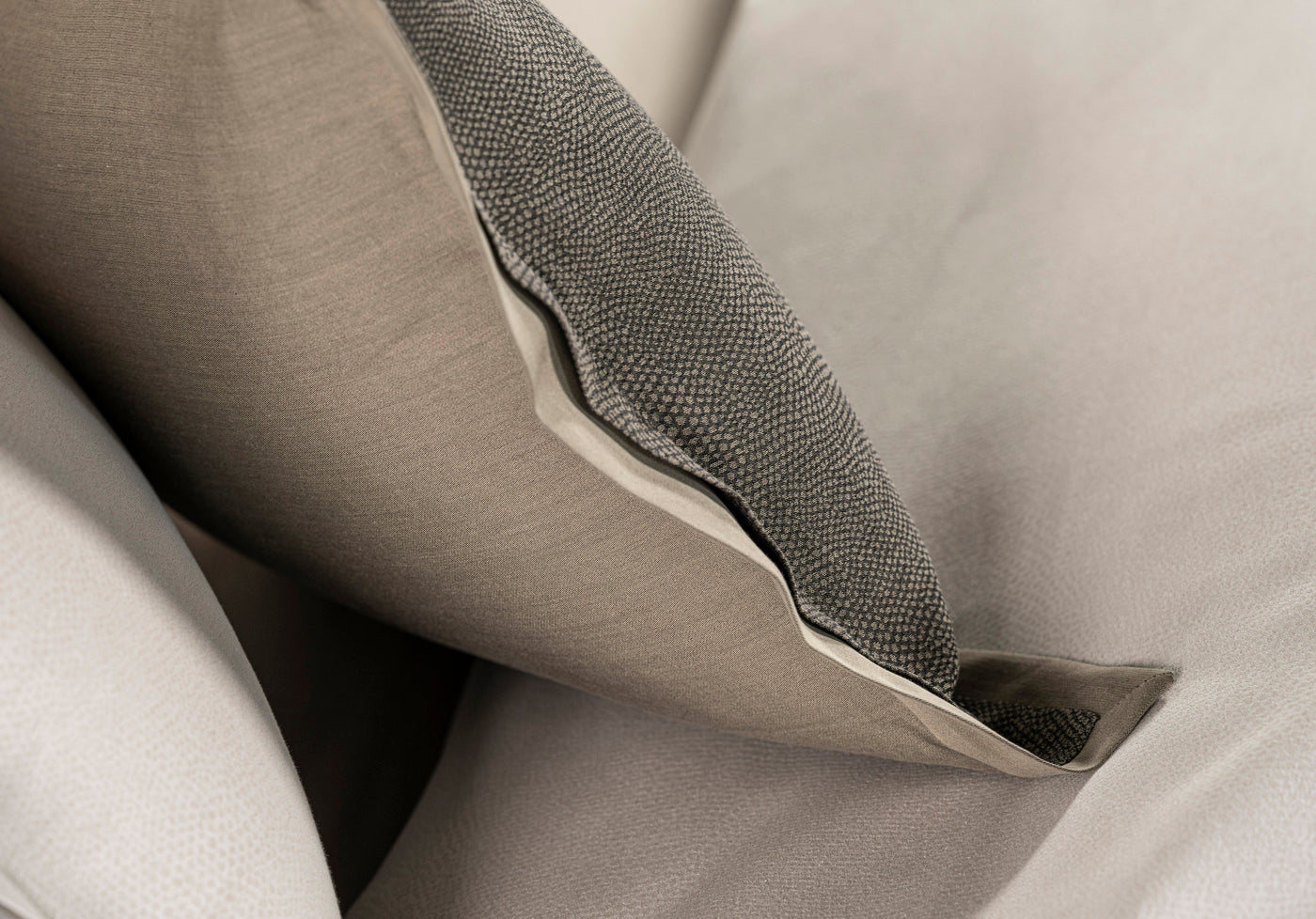 Close-up of neutral-toned textured pillowcases layered, featuring Kroco Pillowcase by Celso de Lemos available at Linen Society.