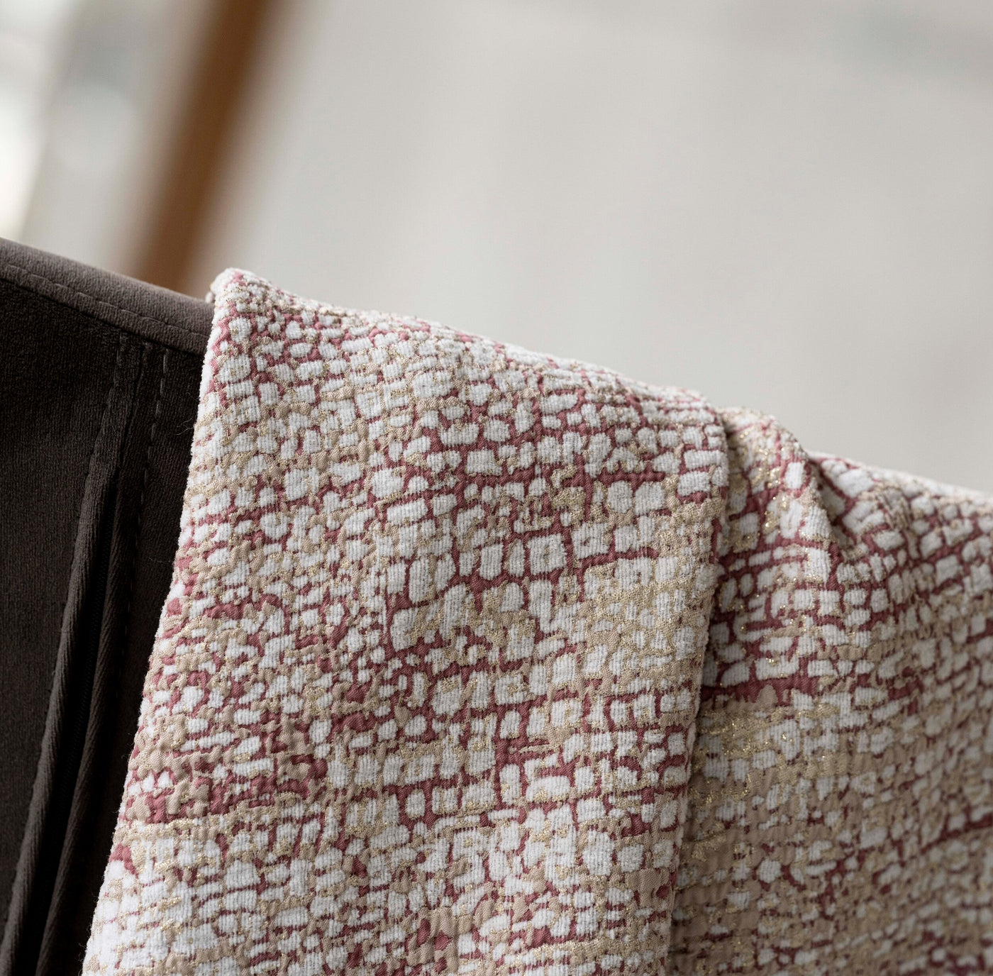 Close-up texture of a woven bed cover with a raised pattern in white, gold, and dusty rose, featuring Lems Bed Cover by Celso de Lemos available at Linen Society.