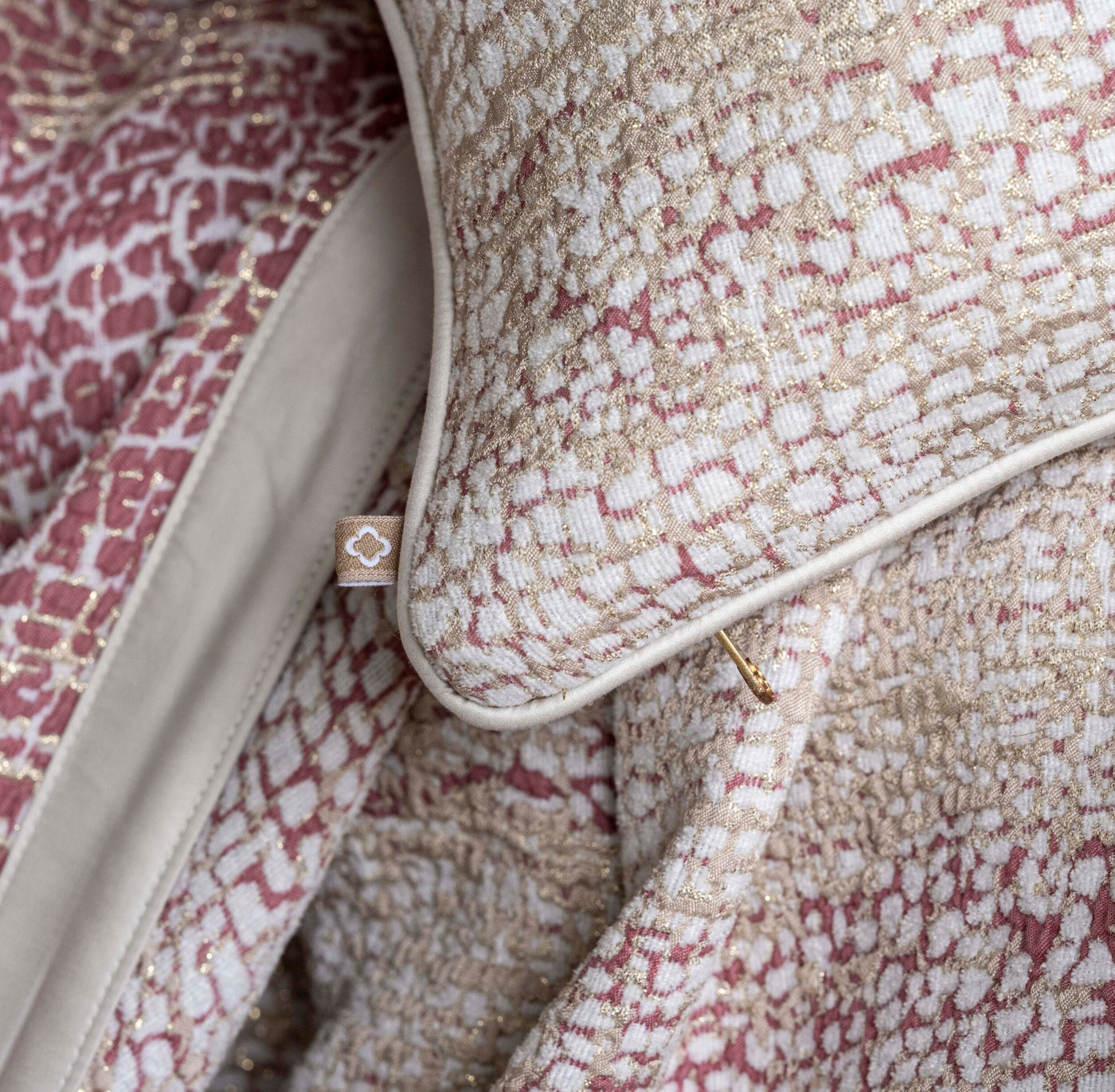 Close-up of a textured pillow with a woven pattern in cream, gold, and subtle rose, featuring the Lems Pillow Cover by Celso de Lemos available at Linen Society.