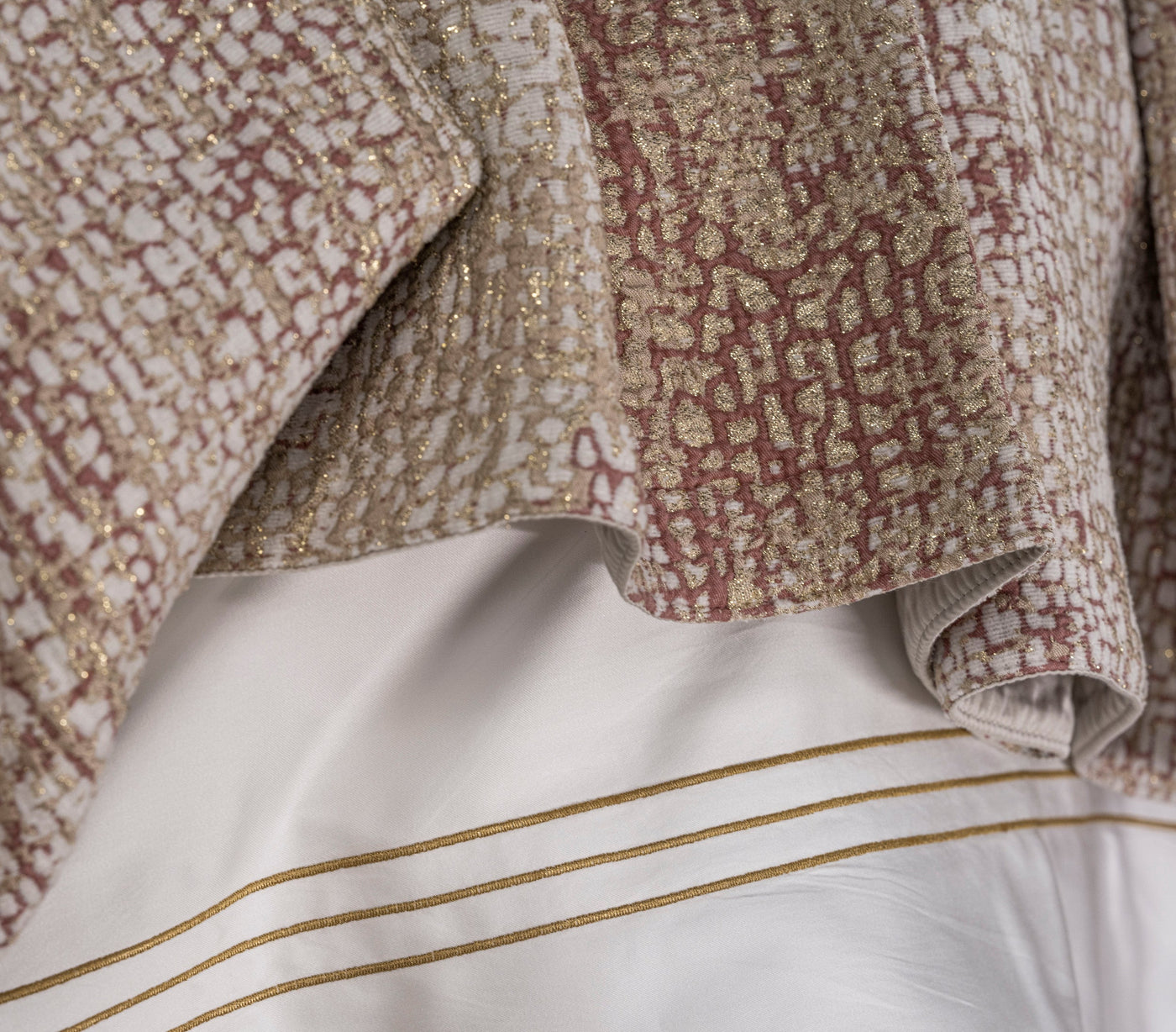 Textured fabric with gold accents and embroidered details on white, featuring Lems Pillow Cover by Celso de Lemos available at Linen Society.