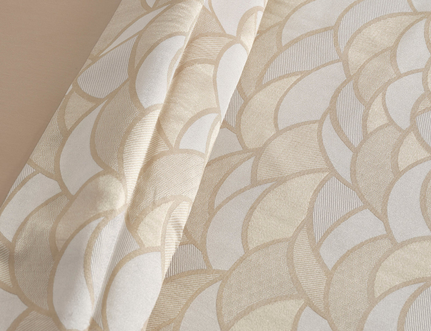 Close-up view of draped fabric with a geometric pattern in beige and cream, featuring Loulou Duvet Cover by Celso de Lemos available at Linen Society.