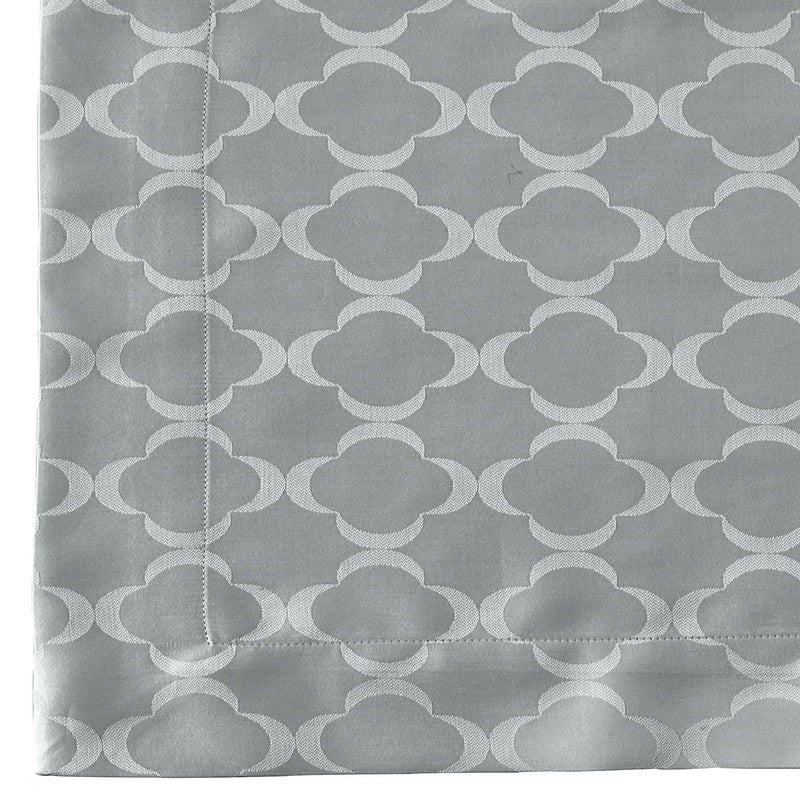 Close-up of a grey fabric with a subtle, embossed quatrefoil pattern, featuring Lua Pillowcase by Celso de Lemos available at Linen Society.