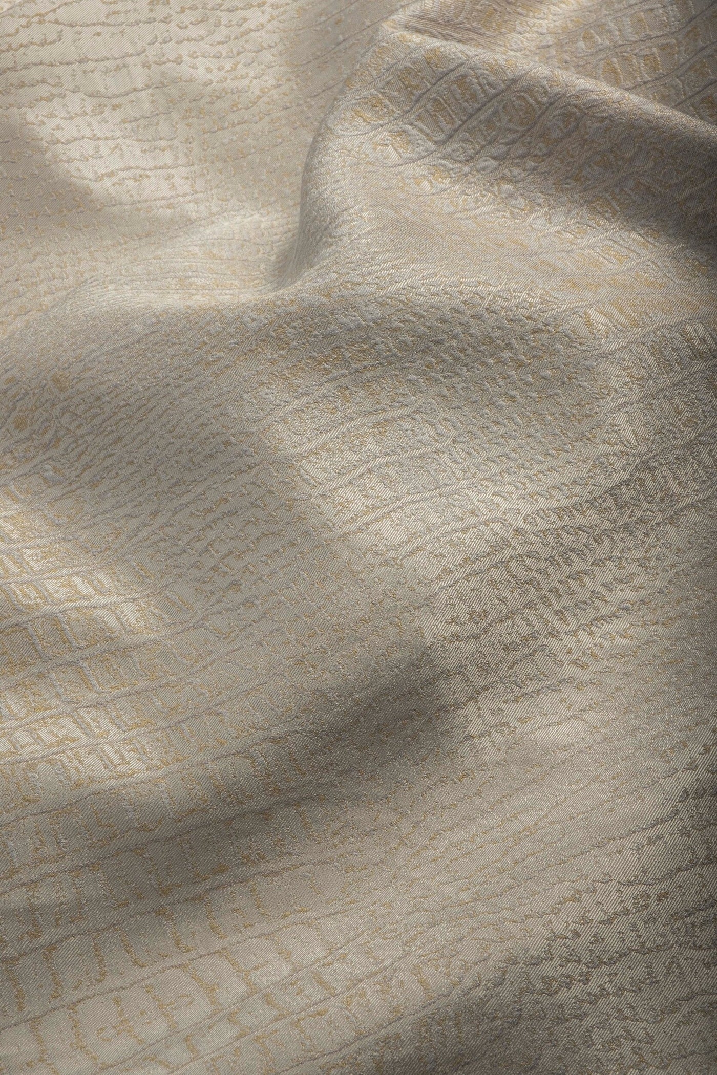 Draped beige fabric with a subtle raised pattern and textured weave, featuring Luxe Pillow Cover by Celso de Lemos available at Linen Society.