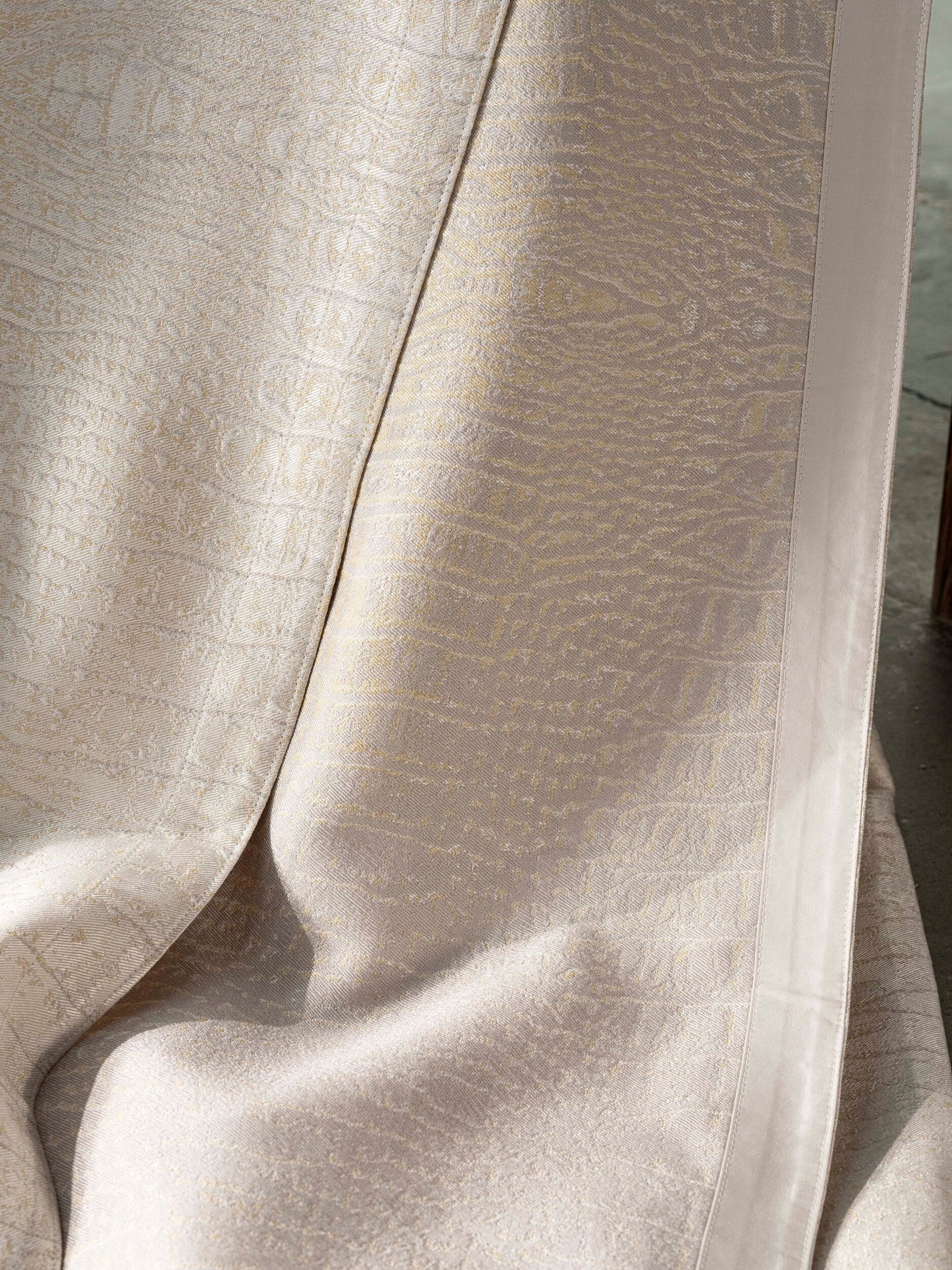 Draped textured fabric in neutral tones with a subtle woven pattern, featuring the Luxe Pillow Cover by Celso de Lemos available at Linen Society.