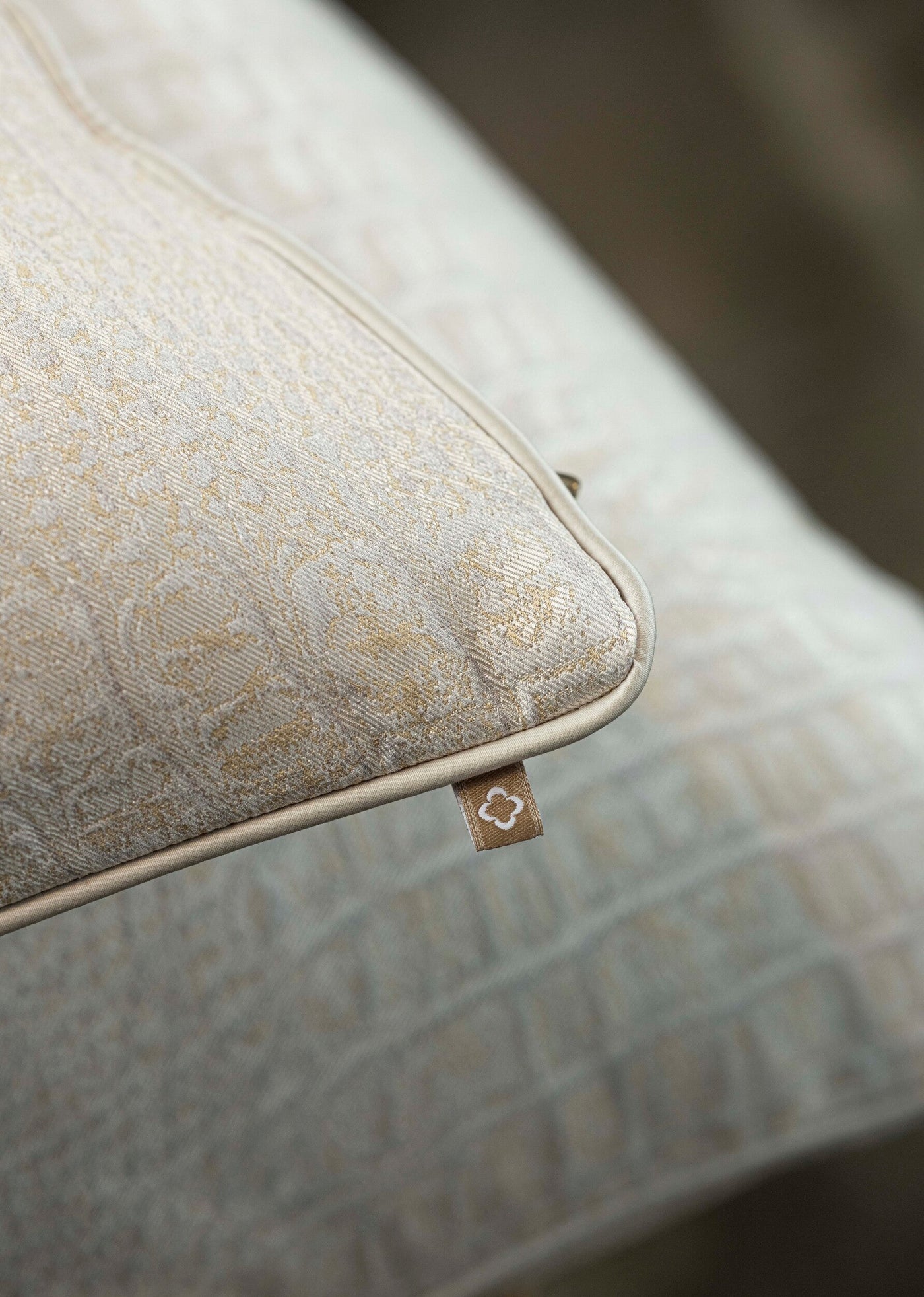 Close-up of a neutral-toned woven cushion with subtle pattern and piped edging, featuring Luxe Pillow Cover by Celso de Lemos available at Linen Society.