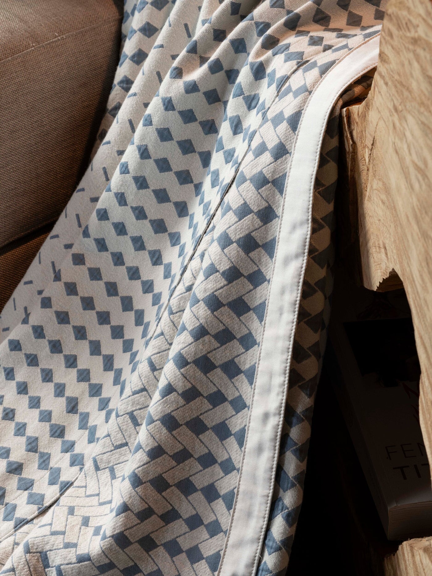 Close-up of a textured fabric with a woven diamond pattern in blue and off-white, featuring Marbella Pillow Cover by Celso de Lemos available at Linen Society.