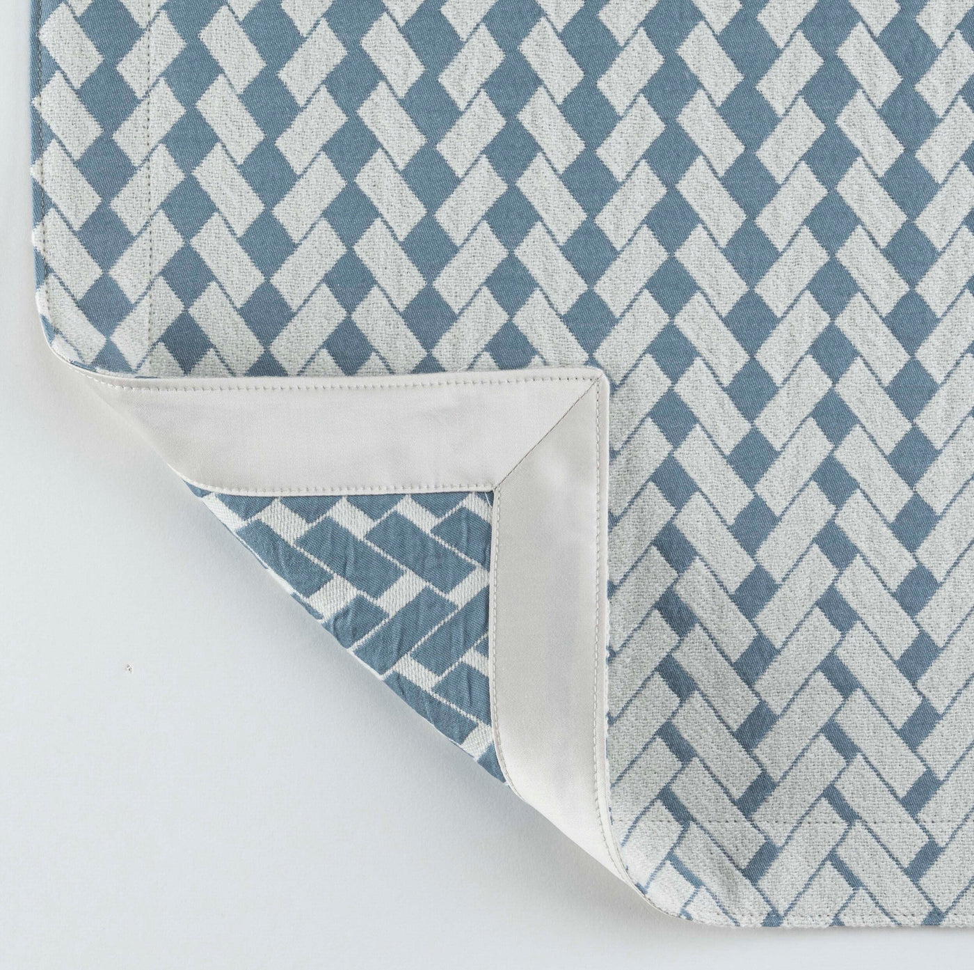 A close-up of a blue and white patterned pillow cover with a textured weave, featuring Marbella Pillow Cover by Celso de Lemos available at Linen Society.