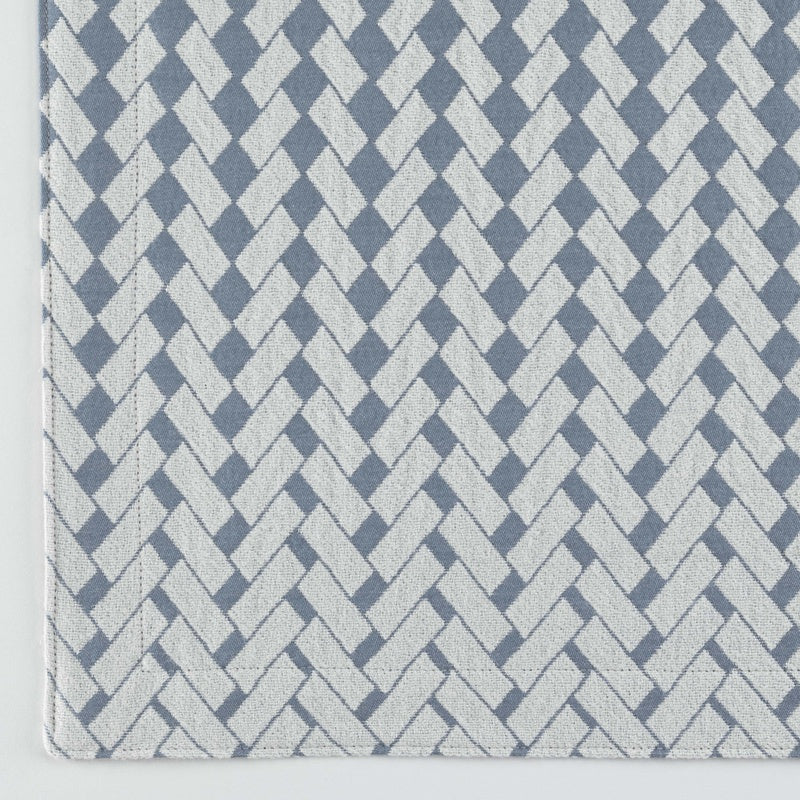 Close-up of a blue and white woven fabric with a herringbone pattern, featuring Marbella Pillow Cover by Celso de Lemos available at Linen Society.