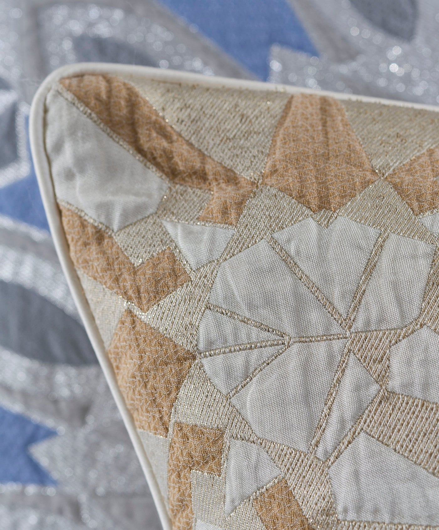 Close-up of a textured pillow cover with a geometric pattern in cream and tan with metallic gold accents. featuring Milena Pillow Cover by Celso de Lemos available at Linen Society.