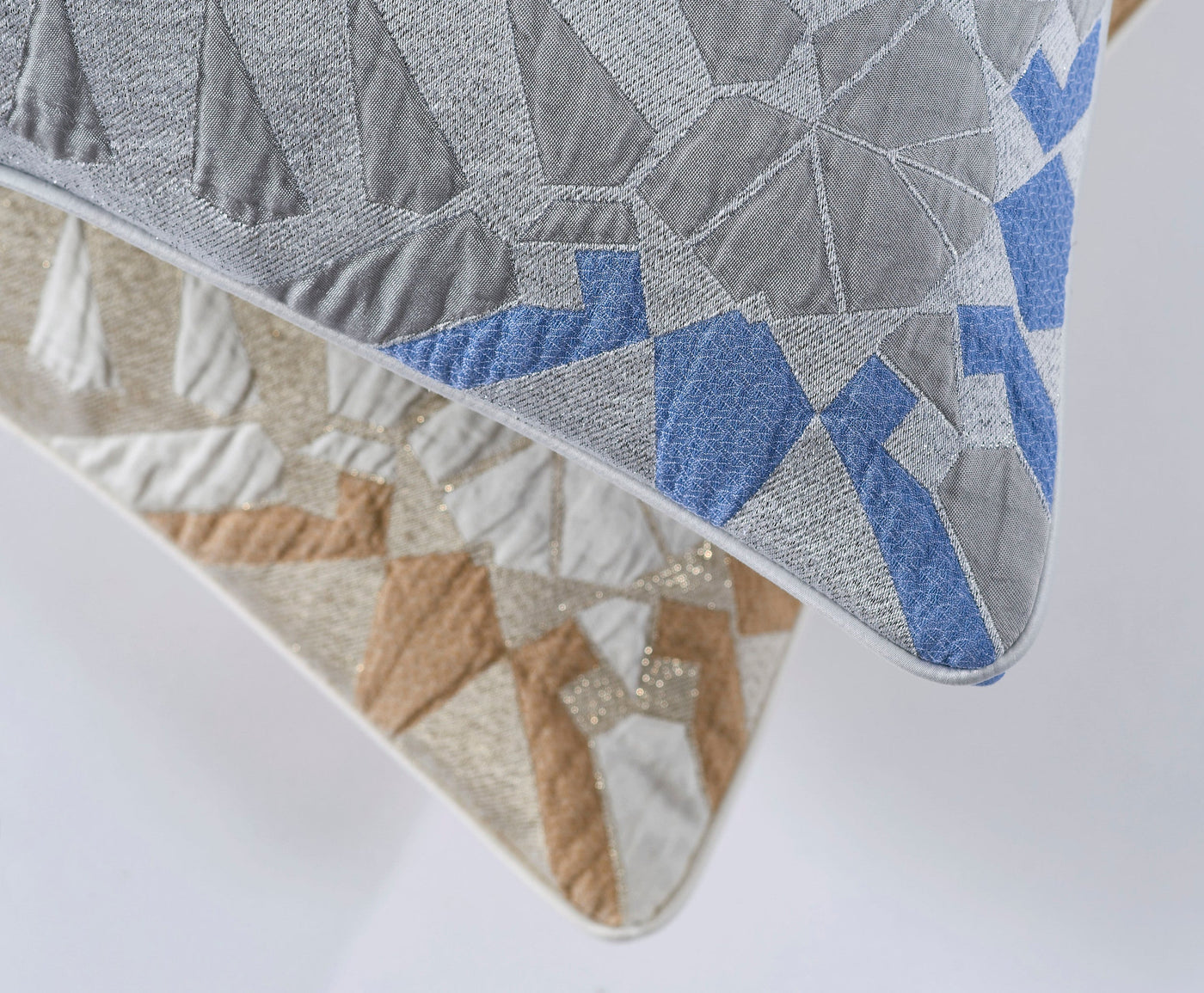 Two decorative pillow covers with geometric patterns in grey, white, and blue, and tan, white, and gold, featuring Milena Pillow Cover by Celso de Lemos available at Linen Society.