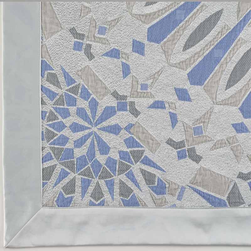 Close-up detail of a woven fabric with a geometric pattern in blue, grey, and white, featuring Milena Pillow Cover by Celso de Lemos available at Linen Society.