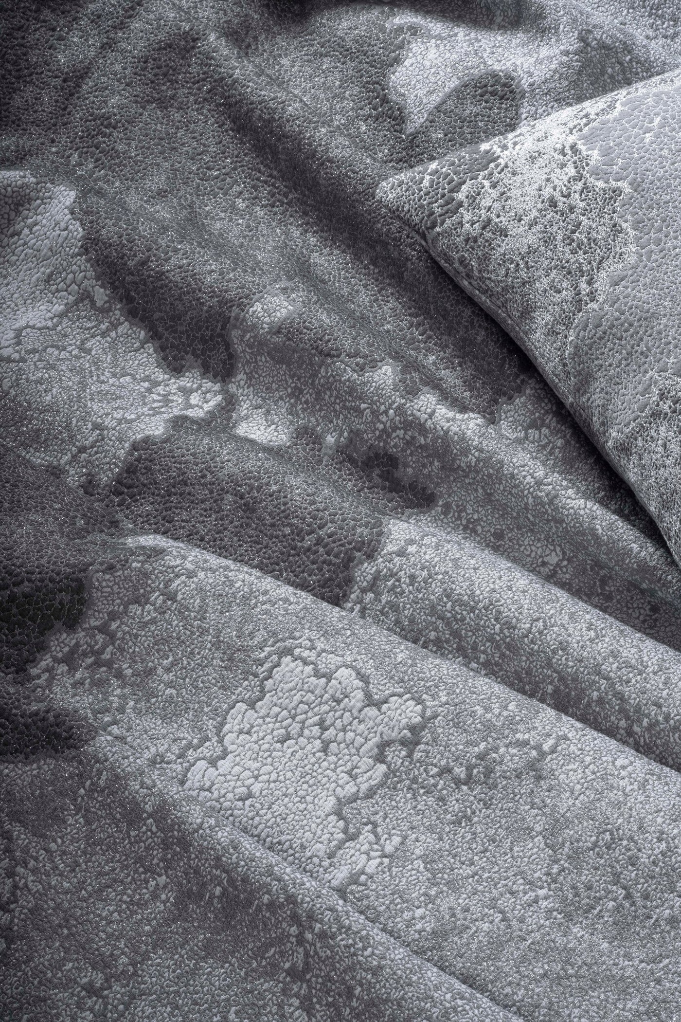 Close-up of textured grey fabric with subtle shimmer, featuring the Mundo Pillow Cover by Celso de Lemos available at Linen Society.