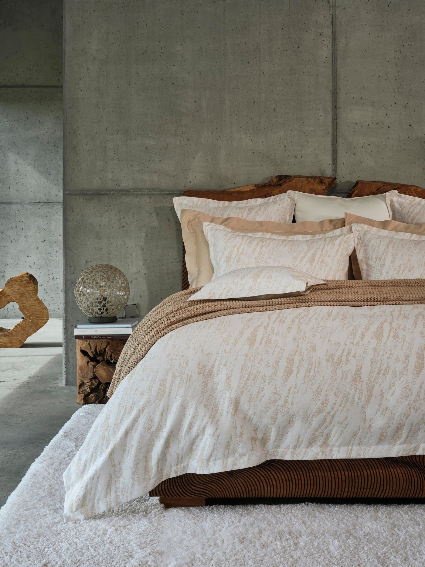 Close-up of Neve pillowcases in ivory with subtle textured pattern against champagne shams.