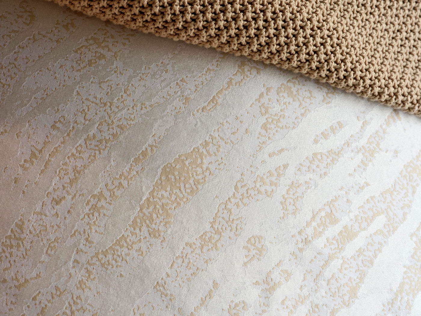 Close-up of Celso de Lemos Neve ivory jacquard texture with champagne abstract pattern.